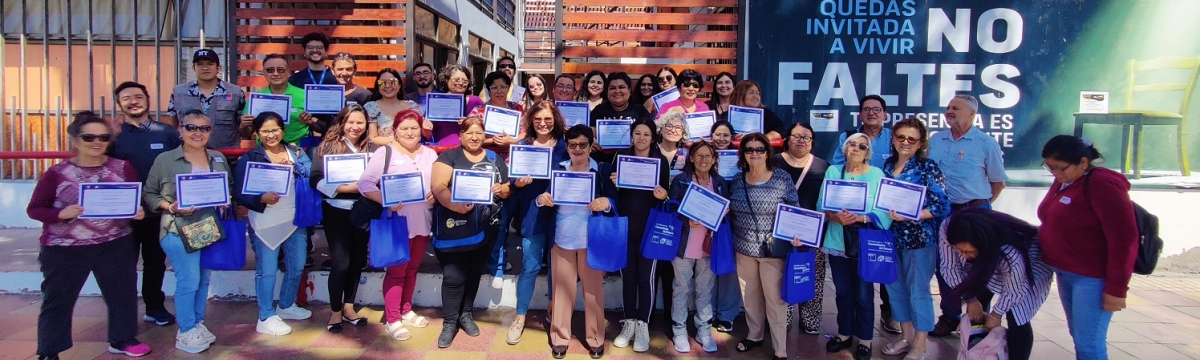 Grupo numeroso de personas posa de pie con certificados