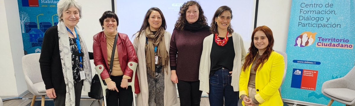Seis mujeres sonriendo para la fotografía frente a una pantalla