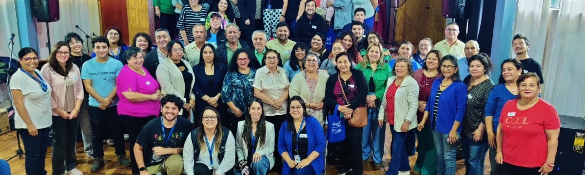Grupo numero de personas mirando a cámara frente a pantalla de presentación de actividad