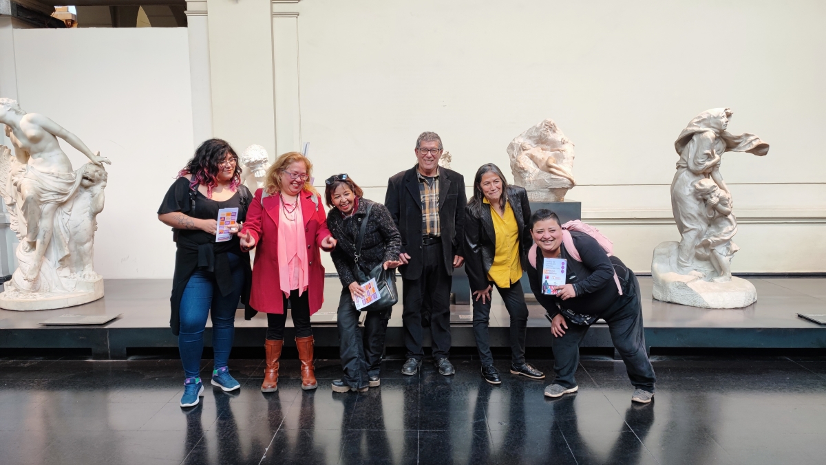 Grupo de personas posa de pie para la cámara frente a estatuas