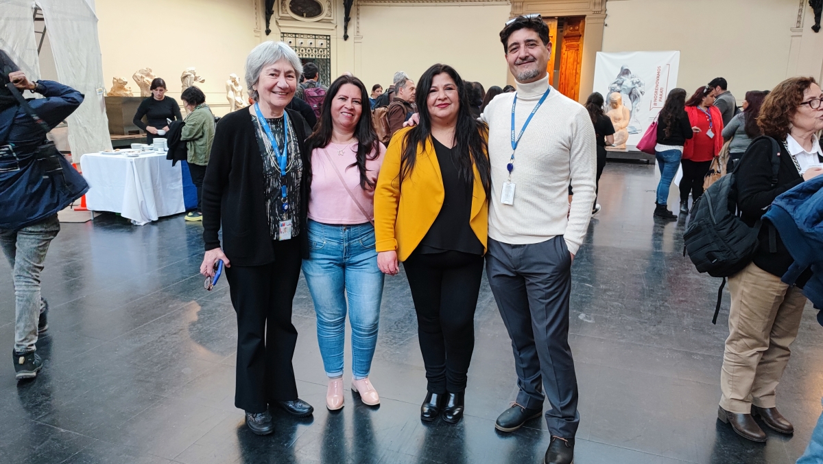 Cuatro personas de pie sonríen para foto en hall del Museo de Bellas Artes
