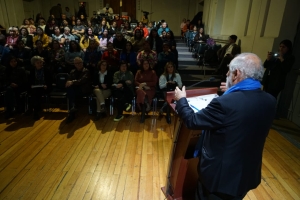Ministro Montes habla desde un podio a personas sentadas en salón