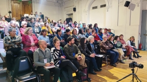 Grupo numeroso de personas sentadas en un salón
