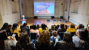 Patricia Boyco habla desde el podio a grupo de personas sentadas en el salón