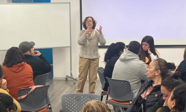 Mujer expone ante sala con personas