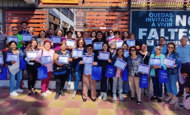 Grupo numeroso de personas posa de pie con certificados