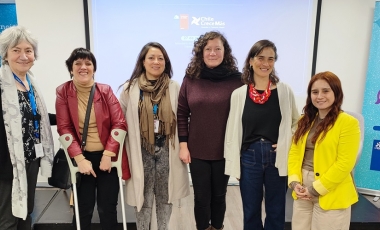 Seis mujeres sonriendo para la fotografía frente a una pantalla