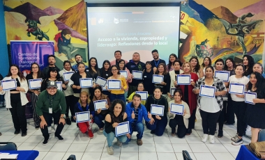 Grupo de personas de pie e hincadas sosteniendo certificados en sus manos