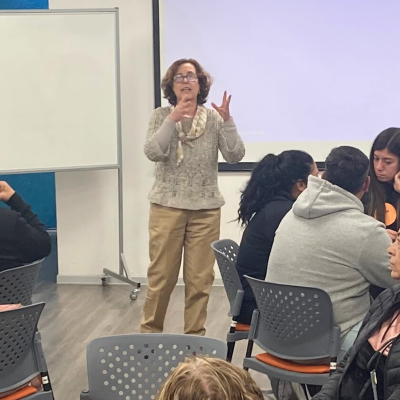 Mujer expone ante sala con personas