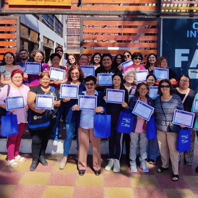 Grupo numeroso de personas posa de pie con certificados