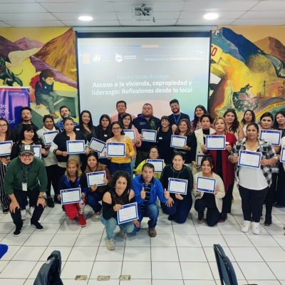 Grupo de personas de pie e hincadas sosteniendo certificados en sus manos